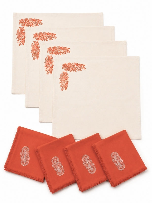 Set of four hand-painted orange floral cotton table mats with four matching napkins displayed together.