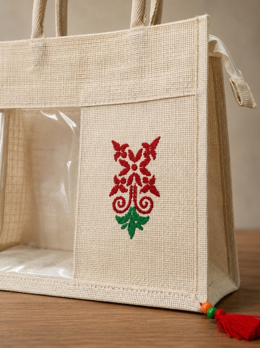 Close-up of the handcrafted cotton jute tiffin bag showing the hand-painted artwork, transparent front window, zip closure, and decorative tassel.