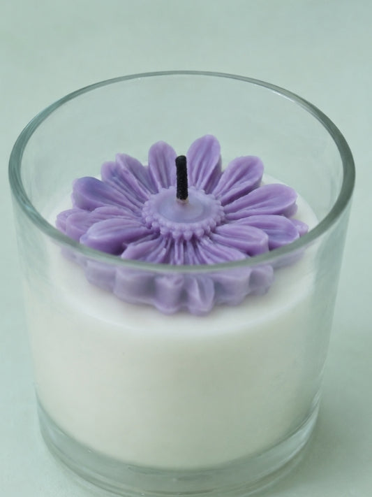 Close-up of the light purple soy wax candle highlighting the dried flower decoration, smooth wax finish, and cotton wick.