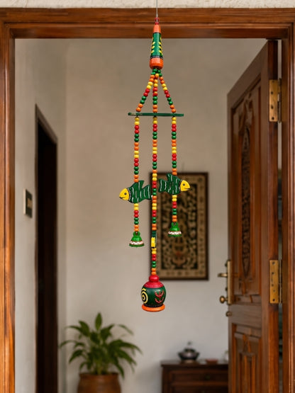 Handcrafted ceramic bell hanging displayed on a doorway, adding colour and handcrafted charm to the entrance.
