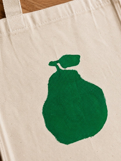 Close-up of the hand-painted pear design showing the stencil details, canvas texture, and stitching
