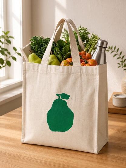  Pear-design cotton canvas tote bag being used for shopping or carrying everyday essentials.
