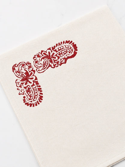 Close-up of the red floral artwork on the cotton table mat, showing the hand-painted details, fabric texture, and stitching.