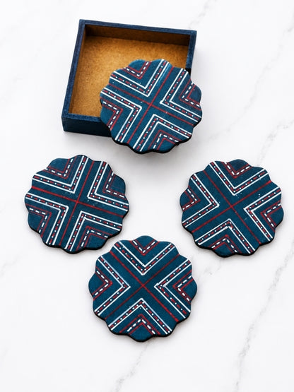 Four handcrafted flower-shaped MDF coasters with hand-painted geometric designs displayed together.

