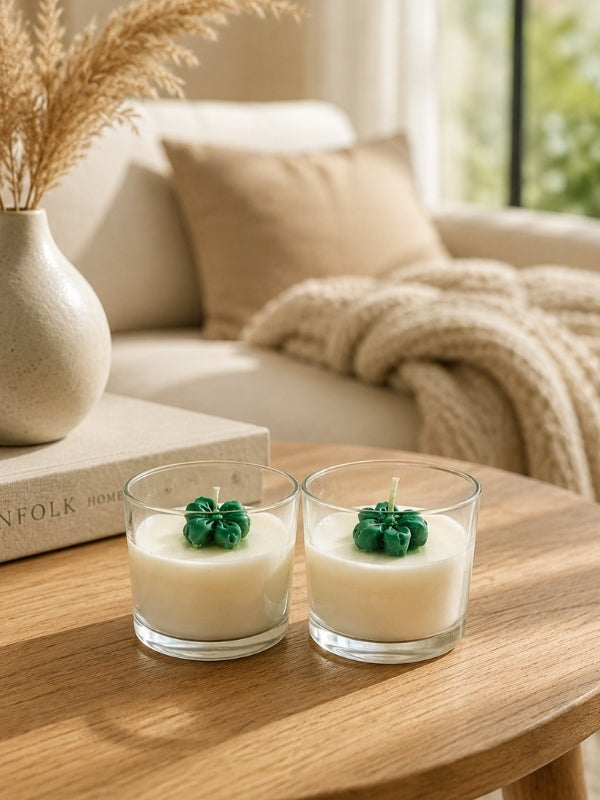 Set of two handcrafted scented soy wax candles in clear glass jars, each measuring approximately 2.25 inches in diameter and 2.25 inches in height, decorated with green wax flowers on the surface.
