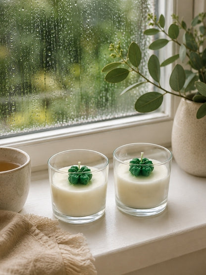 Angled view of the green flower soy wax candle showing the transparent glass jar, decorative wax flower, and handcrafted finish.
