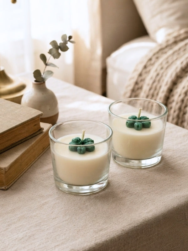 Set of two handcrafted green flower soy wax candles displayed on a dining table or bedside table, adding warmth and fragrance to the space.
