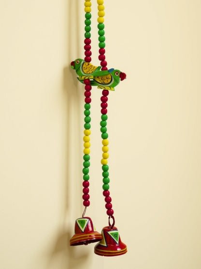 Close-up of the handcrafted parrot decorative hanging showing the painted artwork, bead detailing, and wooden finish.