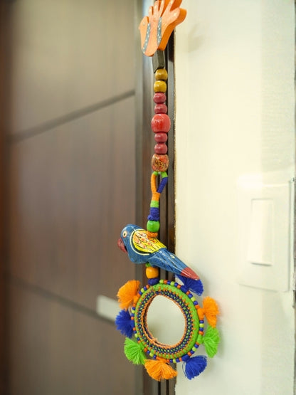 Close-up of the handcrafted bird decorative hanging showing the painted details, wooden beads, and handcrafted finish.