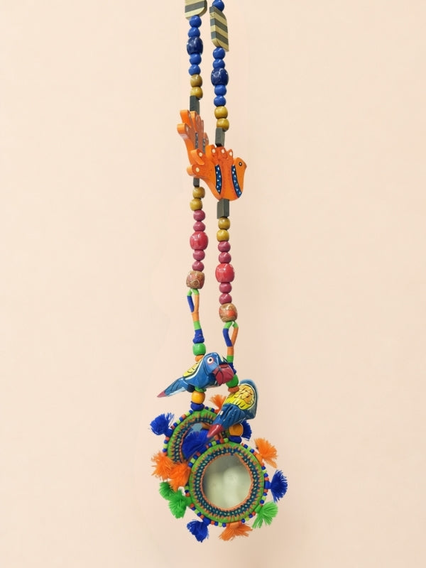 Angled view of the bird door hanging displaying its decorative arrangement and handcrafted construction.