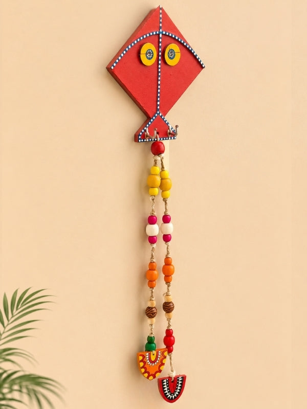 Angled view of the kite key holder displaying its handcrafted construction, hooks, and decorative elements.
