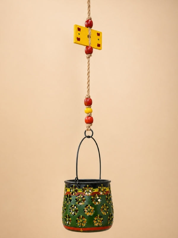 Close-up of the handcrafted metal lantern showing the floral cutwork, thick macramé knots, wooden beads, and decorative finish.