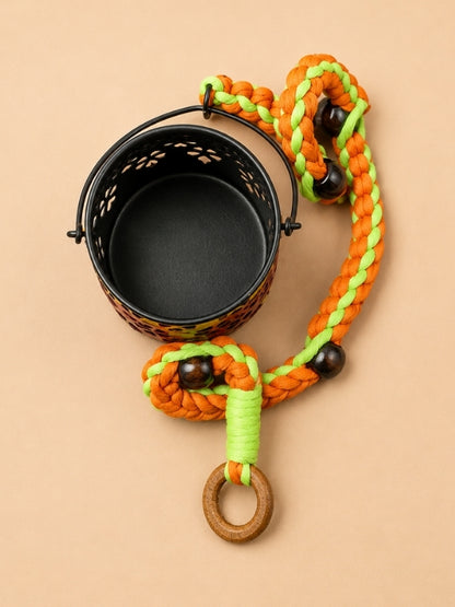 Angled view of the handcrafted tealight holder showing the decorative lantern, fine macramé cord, and hanging structure.
