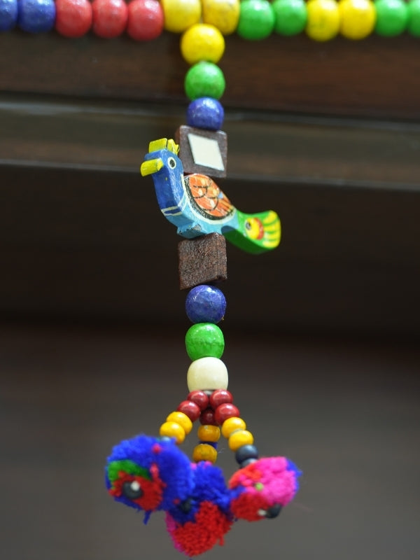 Close-up of the handcrafted peacock wall hanging highlighting the painted details, wood texture, and handcrafted finish.