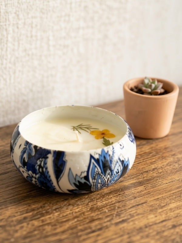 Angled view of the handcrafted botanical soy wax candle showing the floral arrangement and handcrafted finish.