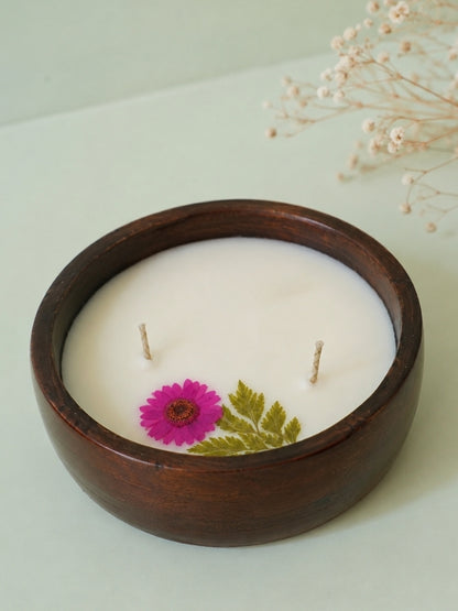 Angled view of the handcrafted decorative soy wax candle showing its floral embellishments and handcrafted finish.