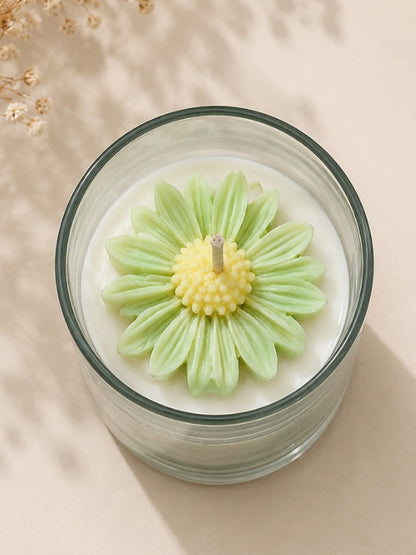 Angled view of the handcrafted light green soy wax candle showing its decorative floral arrangement and handcrafted finish.