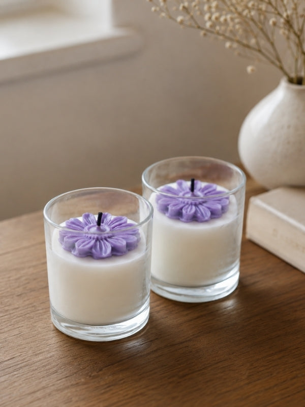 Angled view of the handcrafted light purple soy wax candle showing its decorative floral arrangement and handcrafted finish.