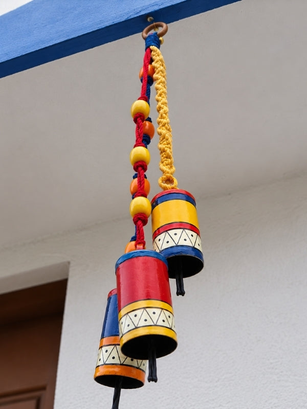 Angled view of the handcrafted metal bell hanging displaying its decorative arrangement and hanging structure.
