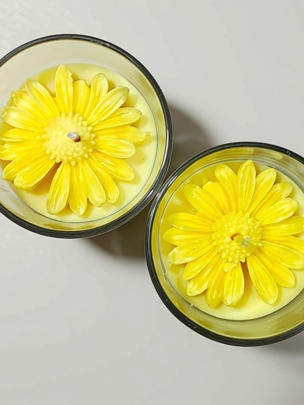 Angled view of the handcrafted yellow soy wax candle displaying the floral decoration and handcrafted finish.
