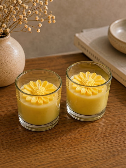 Angled view of the handcrafted yellow soy wax candle displaying the floral decoration and handcrafted finish.
