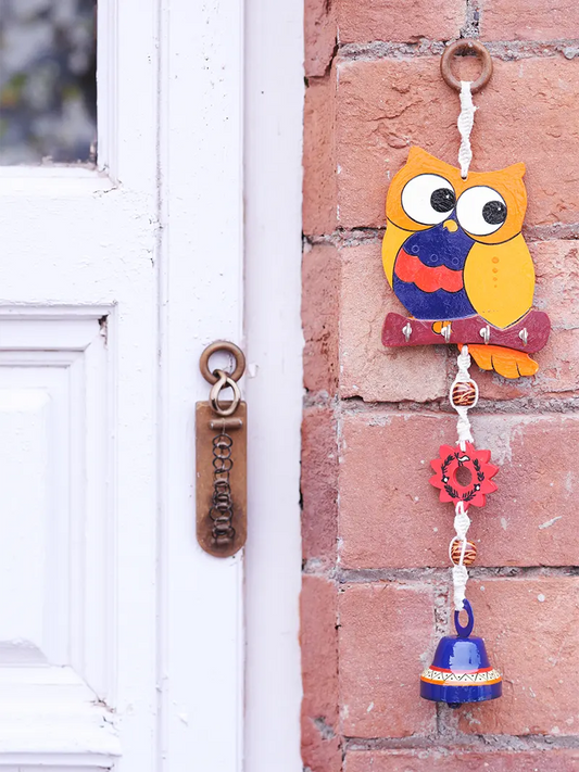 Handcrafted owl key holder mounted near an entrance with keys hanging from the hooks.
