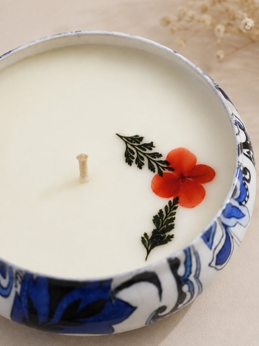Close-up of the handcrafted soy wax candle highlighting the dried flower decoration, smooth wax finish, and cotton wick.
