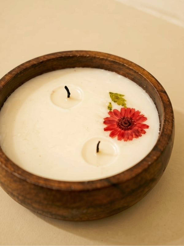 Close-up of the handcrafted soy wax candle highlighting the dried flowers, smooth wax surface, and cotton wick.