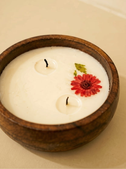 Close-up of the handcrafted soy wax candle highlighting the dried flowers, smooth wax surface, and cotton wick.