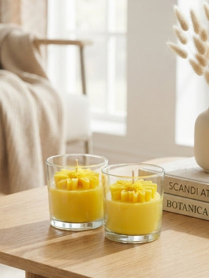 Close-up of the yellow soy wax candle highlighting the dried flower decoration, smooth wax finish, and cotton wick.
