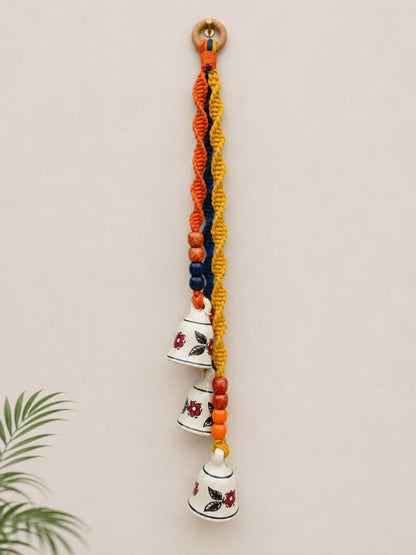 Handcrafted ceramic bell hanging measuring approximately 20 inches in length, featuring three ceramic bells, wooden beads, and macramé cord.
