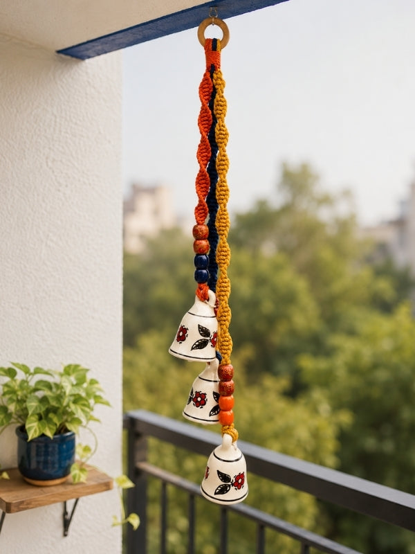 Handcrafted ceramic triple bell hanging displayed on a doorway or balcony, adding warmth and handcrafted character to the space.
