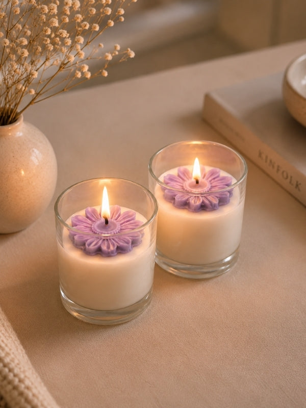 Handcrafted light purple soy wax candle displayed on a coffee table, creating a warm decorative ambience.
