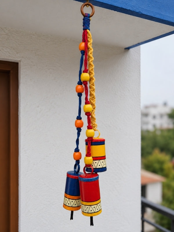 Handcrafted metal bell hanging displayed at a home entrance, adding warmth and traditional decorative charm.
