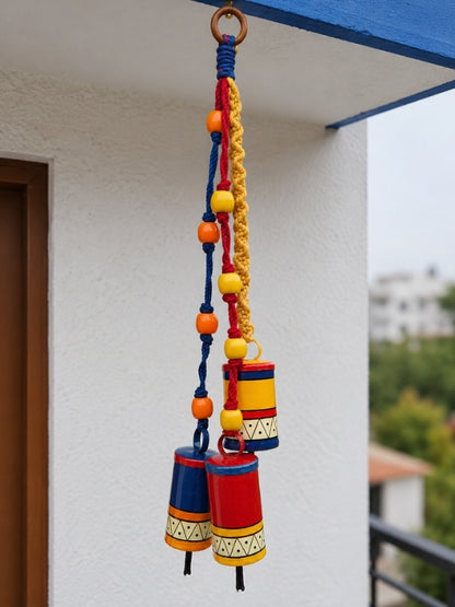 Handcrafted metal bell hanging displayed at a home entrance, adding warmth and traditional decorative charm.
