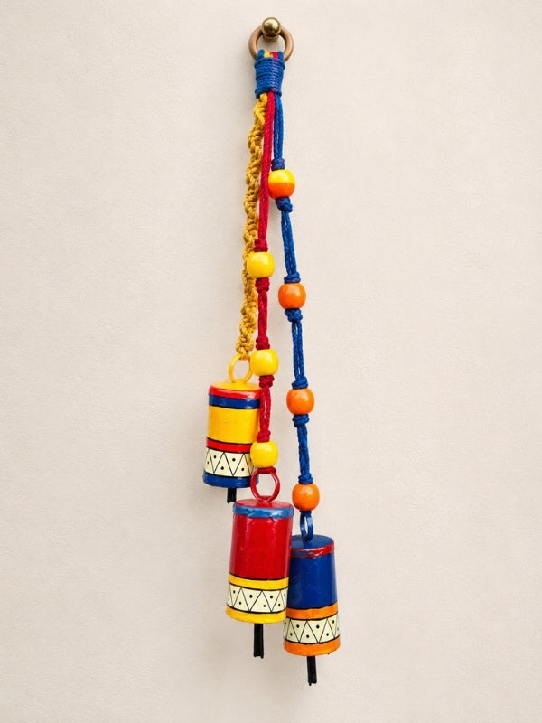 Handcrafted metal bell hanging measuring approximately 23 inches in length, featuring decorative metal bells, wooden beads, and macramé strings.
