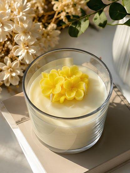 Angled view of the handcrafted yellow soy wax jar candle displaying the transparent glass container, metal lid, and candle depth.