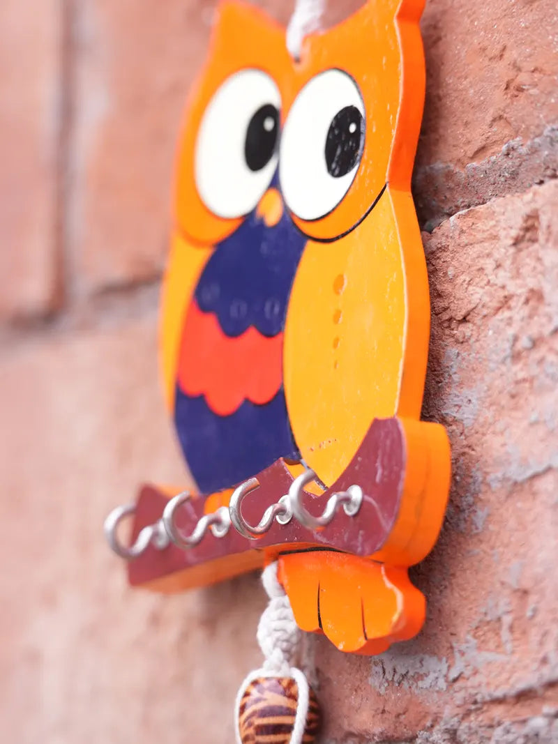 Close-up of the handcrafted owl key holder showing the wooden owl design, macramé knots, and bead detailing.