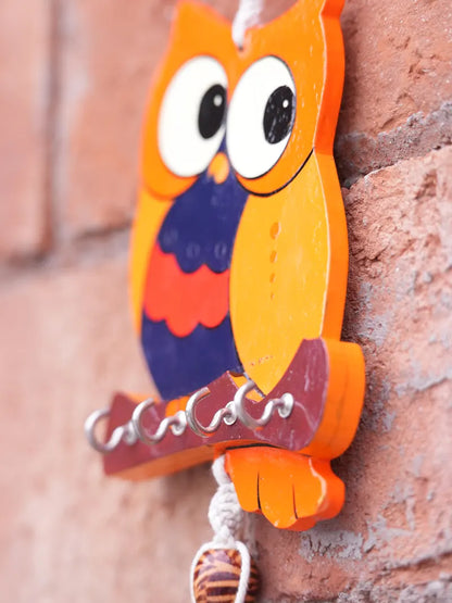 Close-up of the handcrafted owl key holder showing the wooden owl design, macramé knots, and bead detailing.